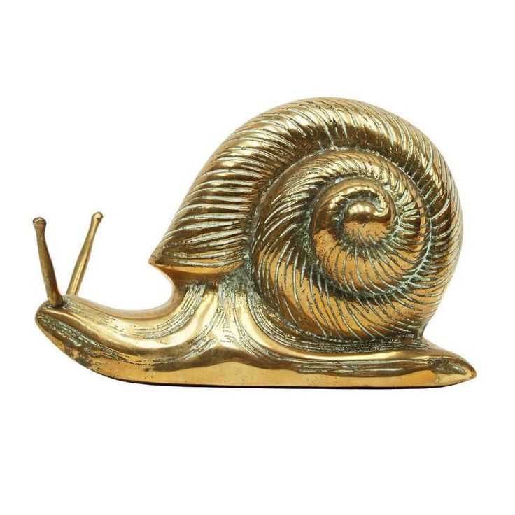 a golden snail figurine on a white background