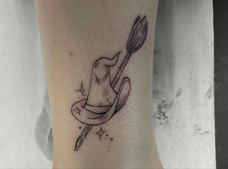 a tattoo on the leg of a woman with a hat and spoon in her hand