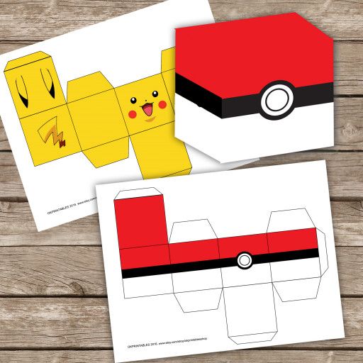 two pokemon papercrafts are shown on a wooden surface, one is yellow and the other is red