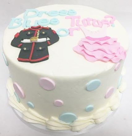 a white cake with pink and blue decorations on it's side, decorated with polka dots