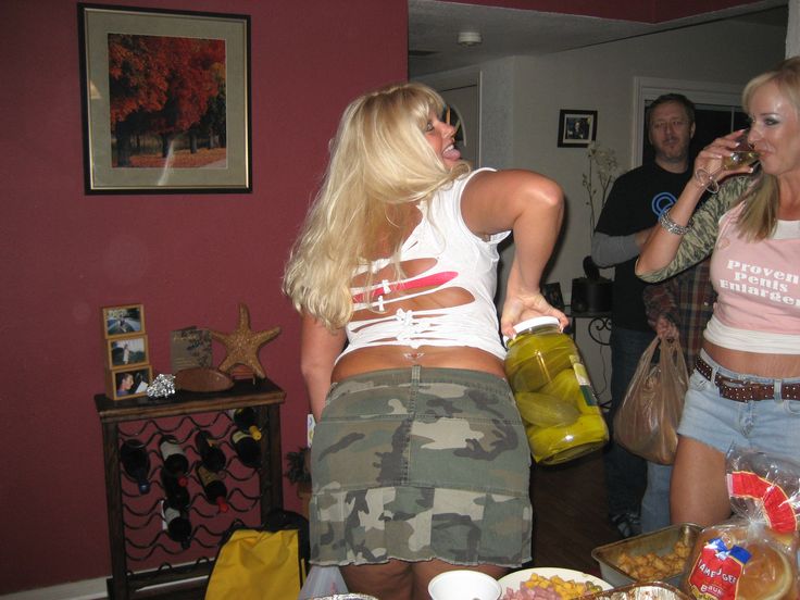 two women in camo shorts are standing near a table full of food and drinks