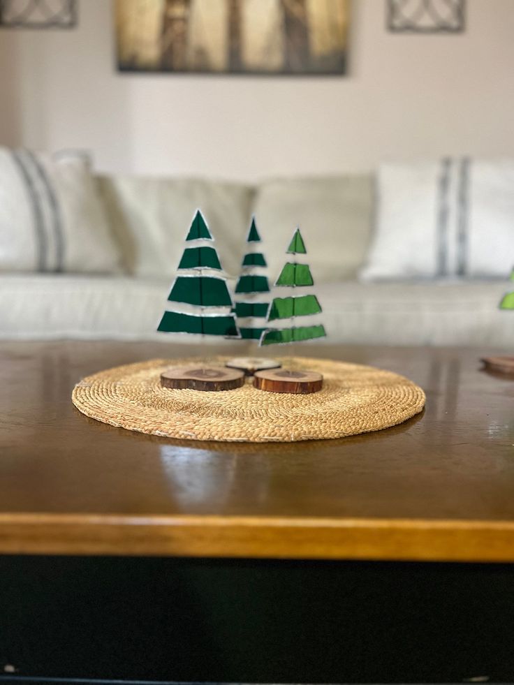 two paper trees sitting on top of a wooden table next to a white couch in a living room