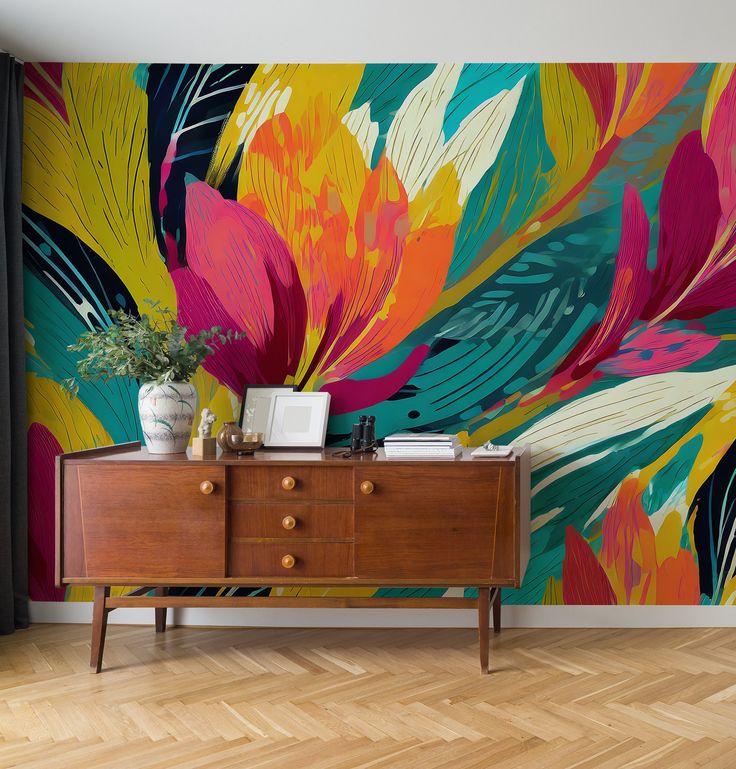 a colorful floral wallpaper in a living room with a wooden dresser and large window