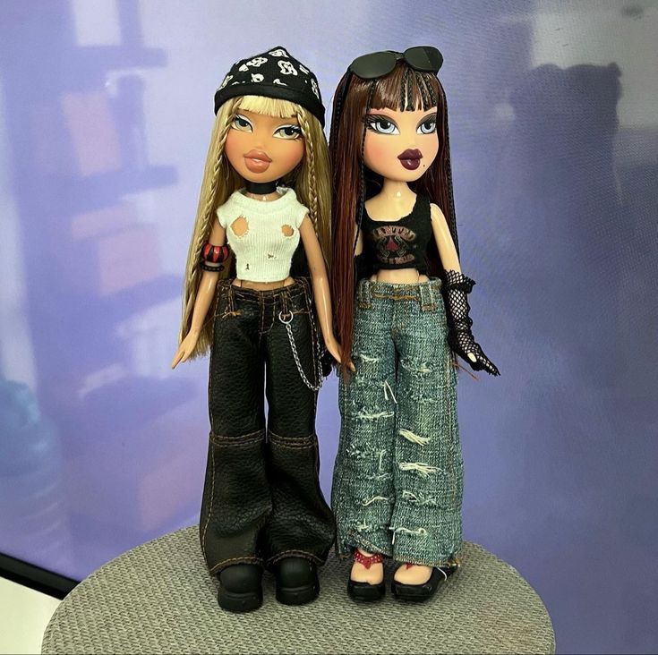 two dolls are standing next to each other