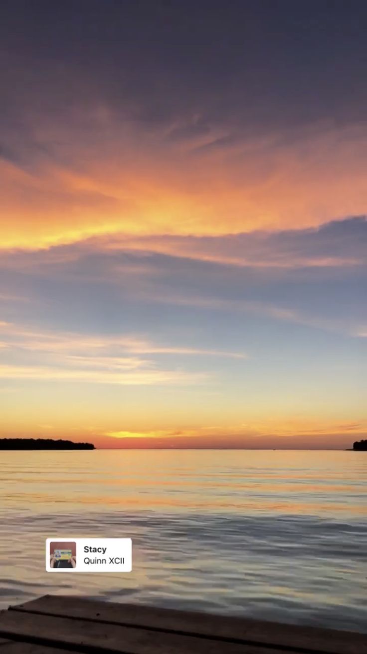 the sky is very colorful and it looks like there are clouds in the sky over the water