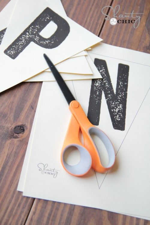 scissors are sitting on top of some cut out letters