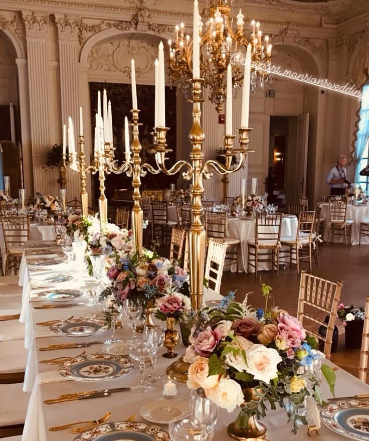 a long table is set up with place settings and centerpieces for an elegant dinner