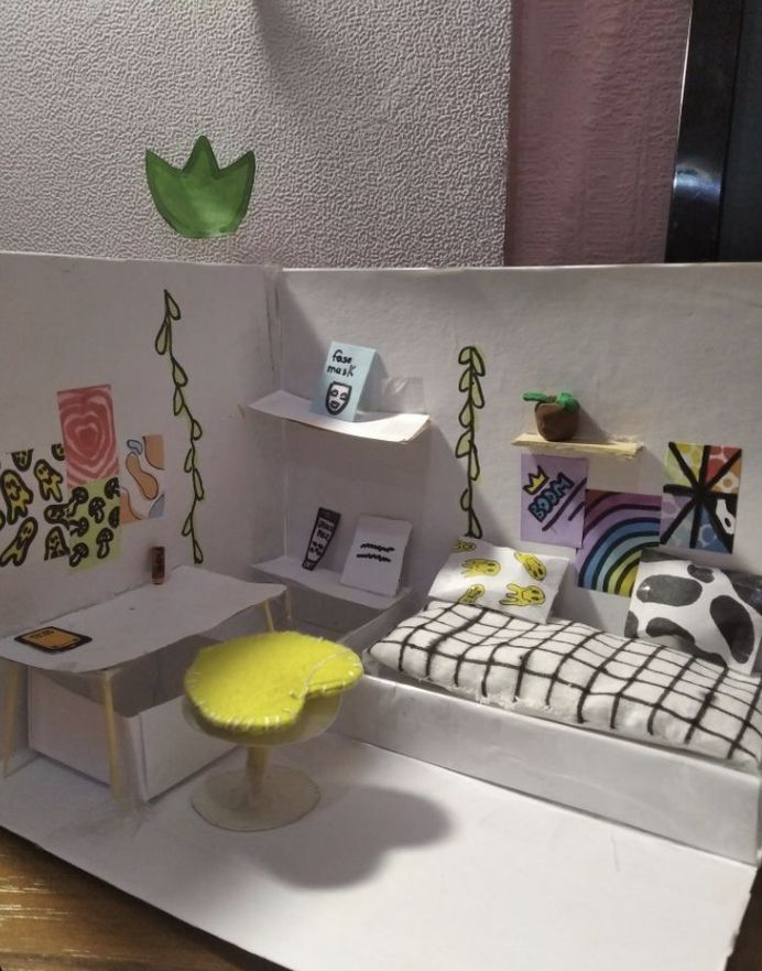 a paper model of a bedroom with furniture and decorations on the walls, including a bed