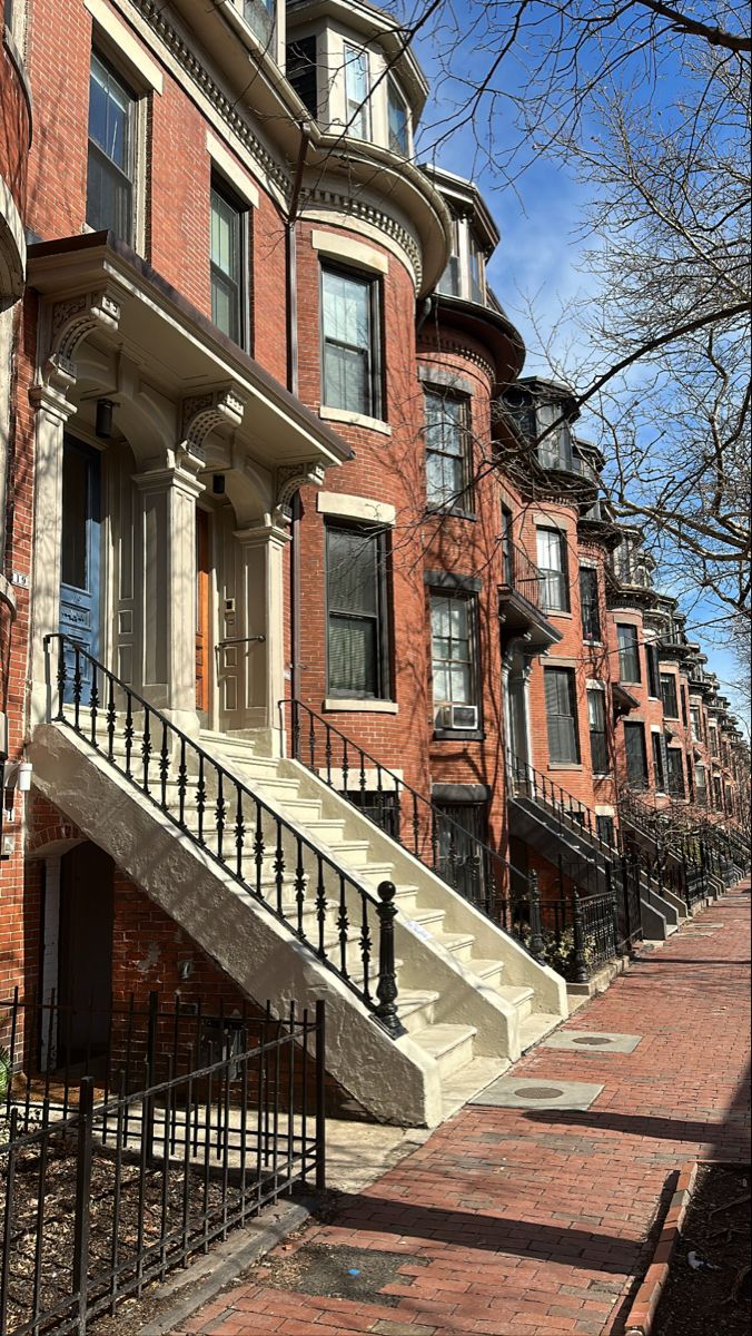 an old brick building with stairs leading up to the front door and second story windows