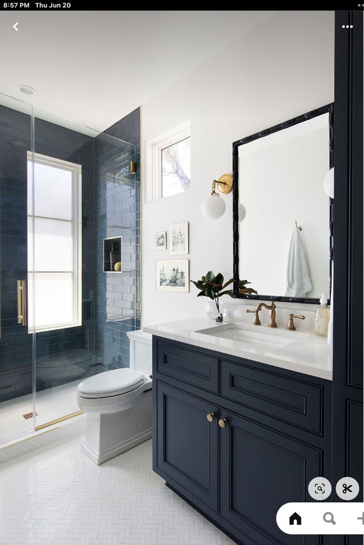 a white and blue bathroom with a large mirror above the sink, toilet and shower