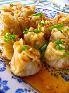 some food is sitting on a blue and white plate with green garnishes