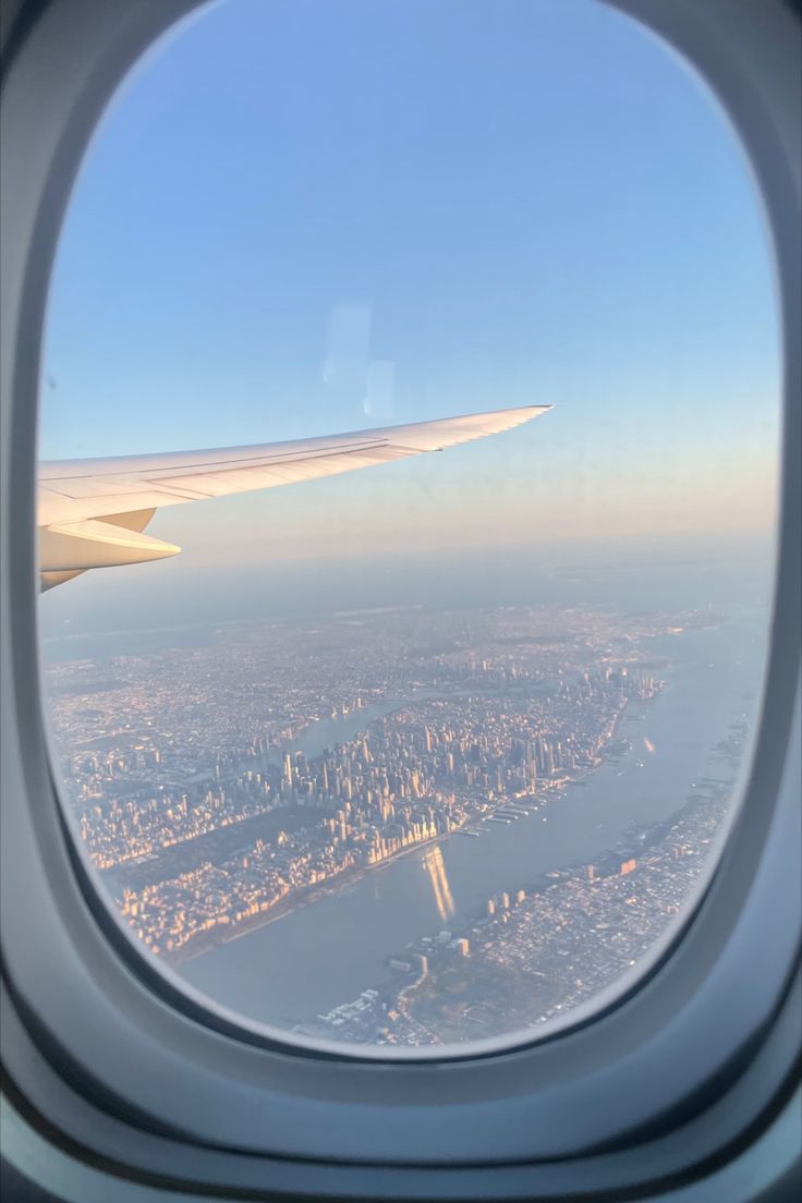 an airplane window looking out at the city below