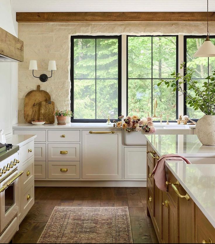 a large kitchen with white cabinets and wooden floors, along with an area rug on the floor