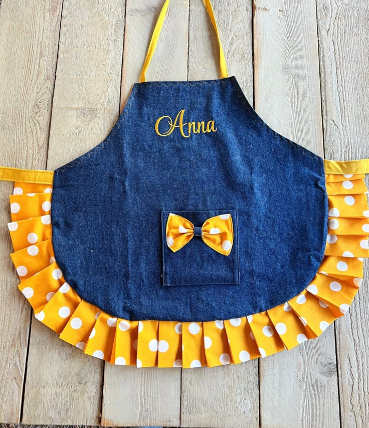 The perfect apron for your little princess!! Fits comfortably around the neck and ties in the back. Also has a pocket to store her little treasures!! The ruffled edge makes your child feel so special!!  Totally reversible and OH so adorable   The fonts are shown - select a font, or font and applique, and thread color(s) As an option, matching oven mitts, hot pads, or chef hat can be ordered and customized.  An apron set consists of apron, hat, and mitts.  Personalization included in price. Sizin Purple Apron, Jean Apron, Child Apron, Toddler Apron, 1950s Sewing Patterns, Diy Pillow Covers, Simple Hand Embroidery Patterns, Girl Apron, Apron Sewing Pattern