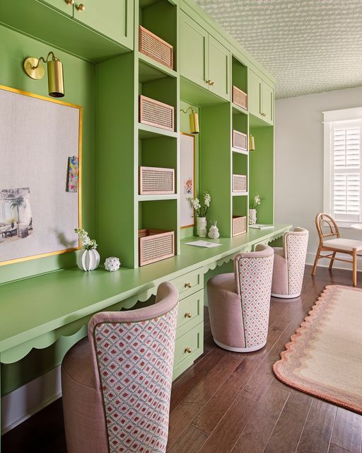 a room with green painted walls and wooden flooring, built in shelving units