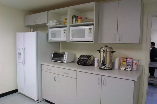 a white refrigerator freezer sitting inside of a kitchen next to a microwave and toaster oven