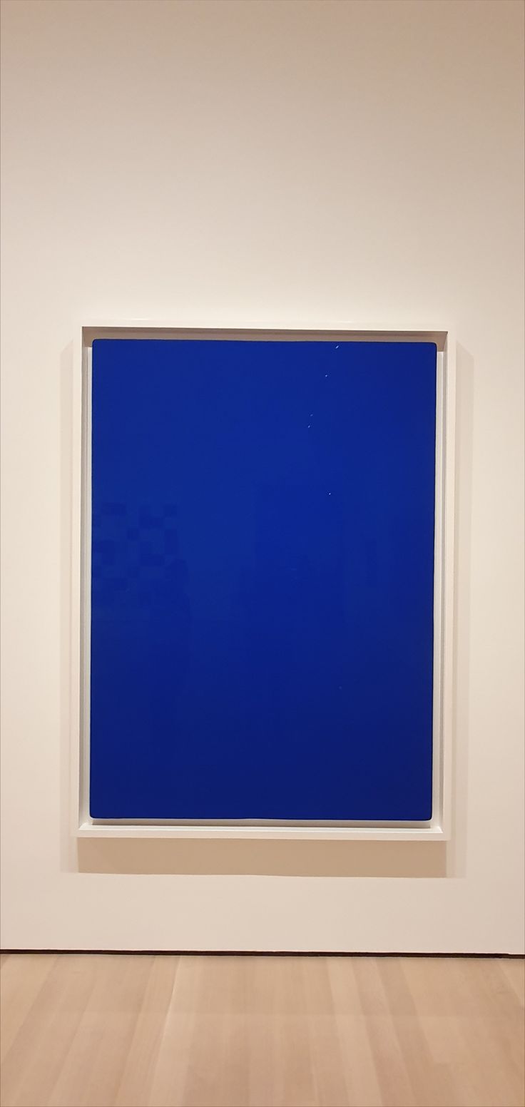 a blue painting in a white room with wood flooring