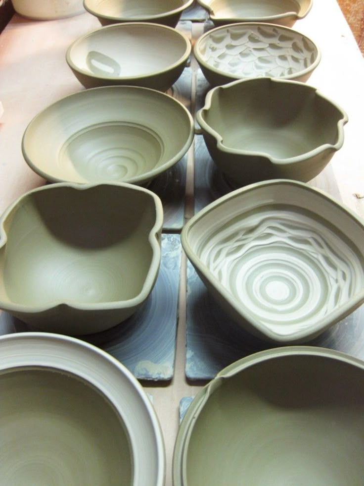 many bowls sitting on top of a table next to each other in different shapes and sizes