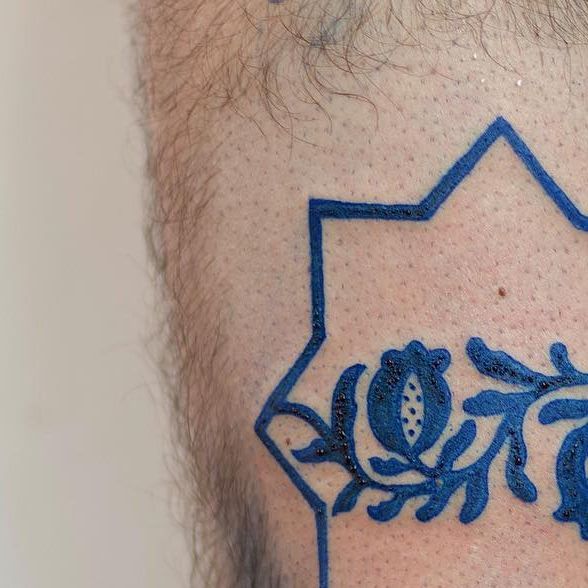 a close up of a man's neck with tattoos on it