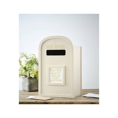 a white mailbox sitting on top of a wooden table next to a potted plant