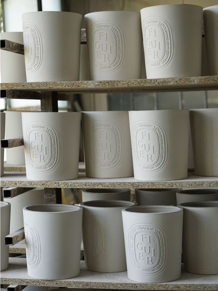 white cups are lined up on shelves in a store