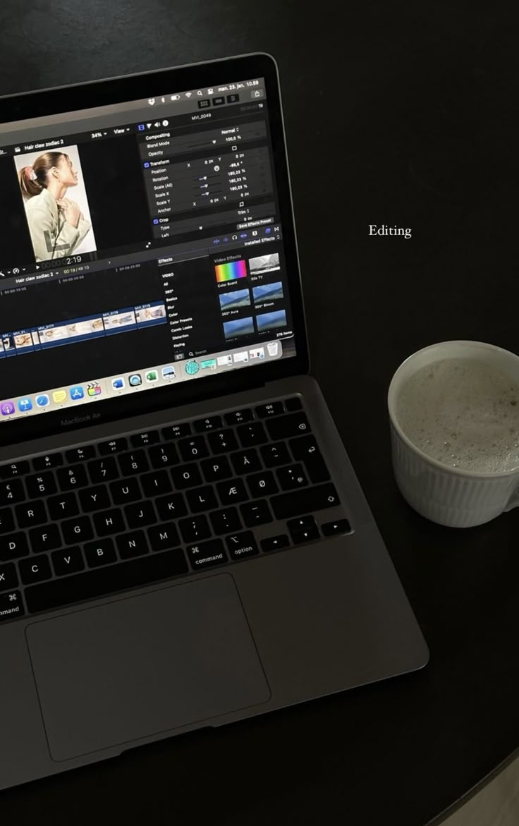 an open laptop computer sitting on top of a table next to a cup of coffee