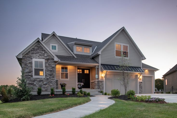 a large house with two garages on the front and side of it at dusk