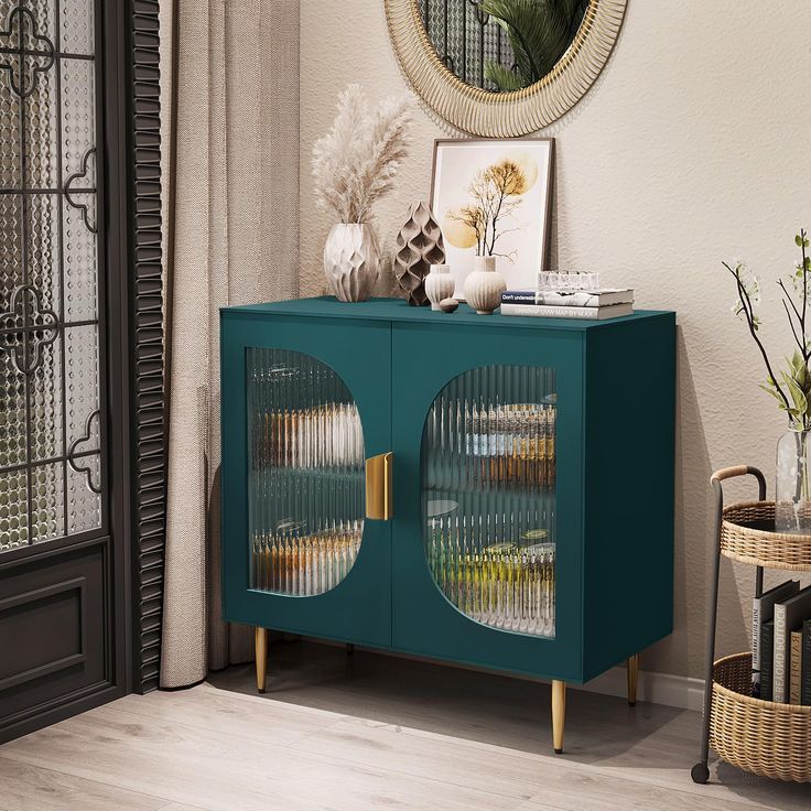 a blue cabinet with two glass doors in front of a mirror and vases on the floor