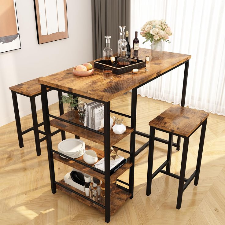 a kitchen table with two stools next to it on a hard wood floor in front of a window