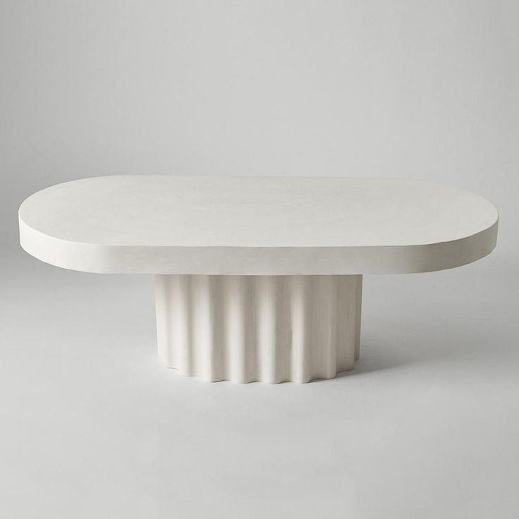 a white table with an oval base on the top and two circular bases at the bottom