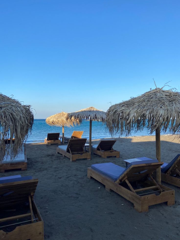 lounge chairs and straw umbrellas on the beach