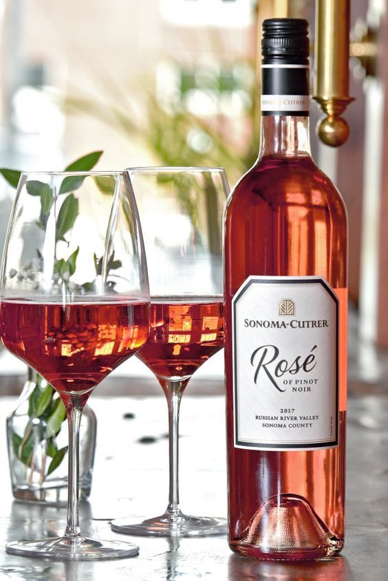 a bottle of rose wine next to two glasses