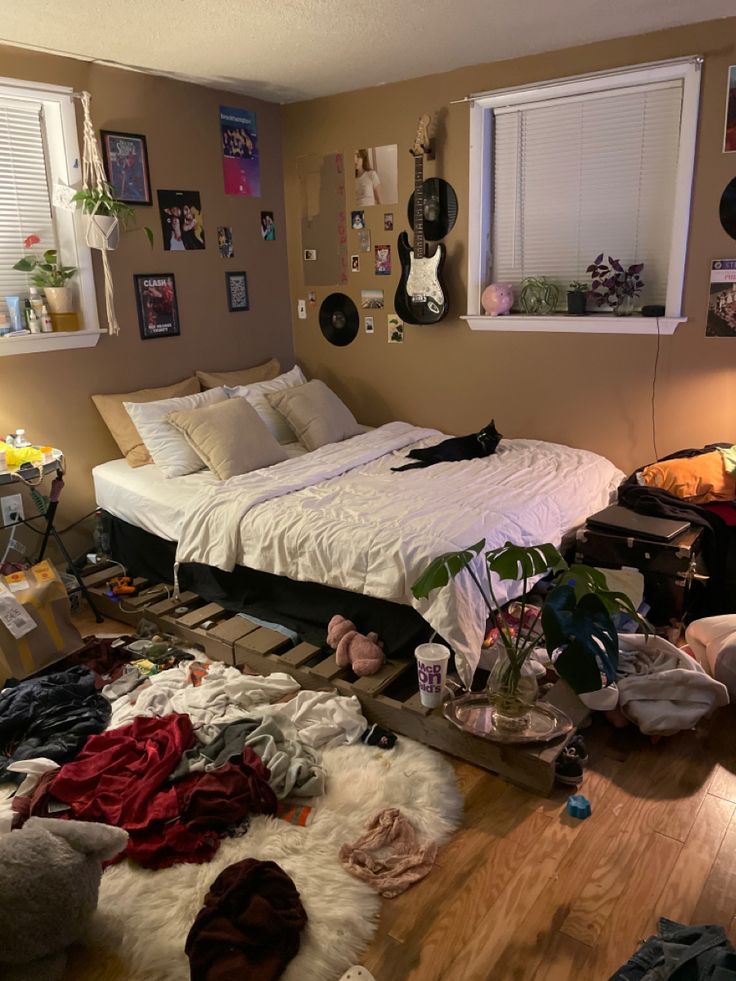 a messy bedroom with clothes scattered all over the floor and bed on the ground next to it