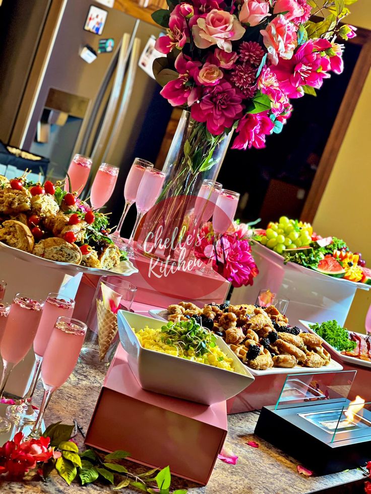 a table topped with lots of different types of food and glasses filled with wine on top of it