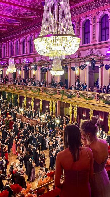 two women standing in front of a large room filled with people