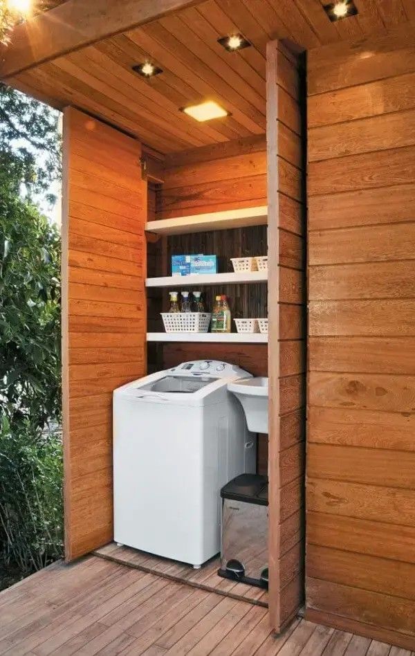 a washer and dryer sitting in the corner of a wooden decked area