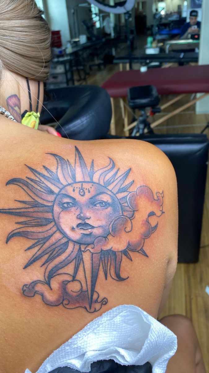 a woman with a sun tattoo on her back