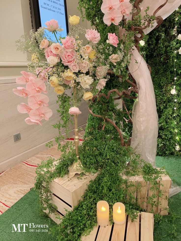 an arrangement of flowers and greenery on display