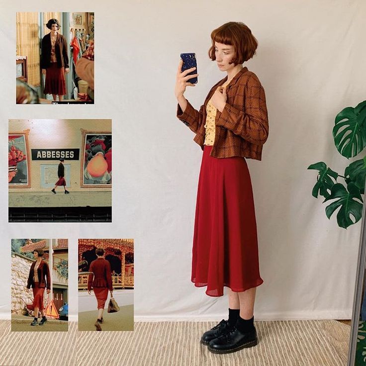 a woman standing in front of a white wall holding a cell phone