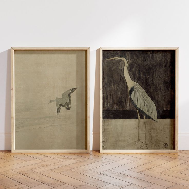 two framed paintings on the wall next to each other, one with a bird in it's beak