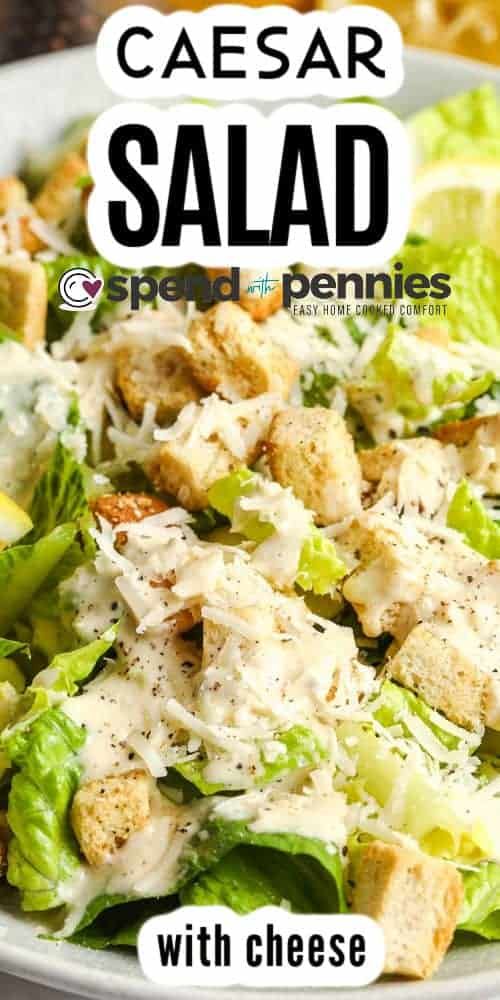 a salad with croutons, lettuce and cheese on it in a white bowl