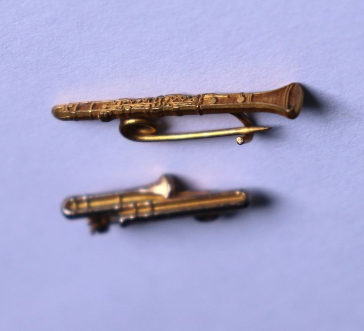 two gold colored objects sitting next to each other on a blue surface with white background