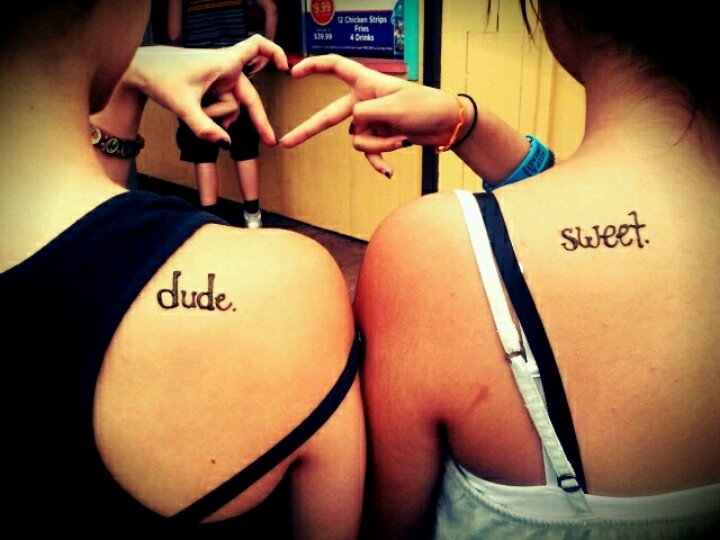 two girls with tattoos on their backs making the words dude and sweet written in cursive writing