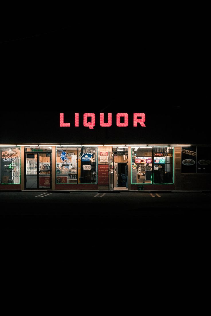 a liquor store lit up in the dark