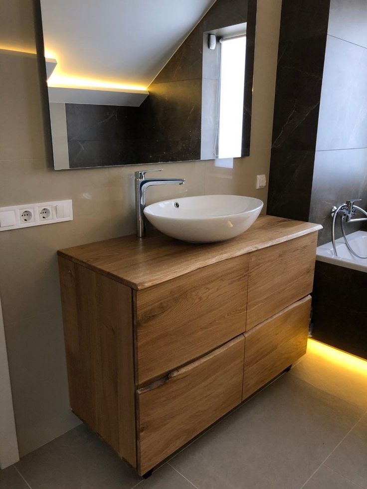 a bathroom sink sitting on top of a wooden cabinet