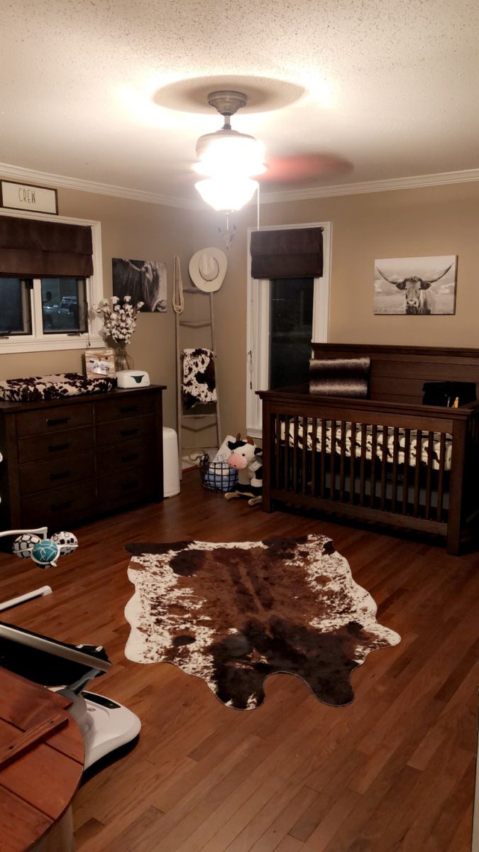 a baby's room is decorated in brown, white and black colors with an animal print rug on the floor