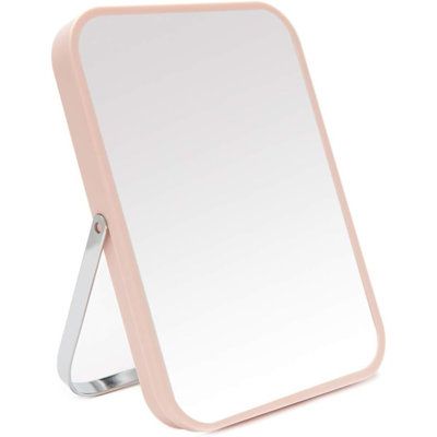 a pink mirror sitting on top of a table