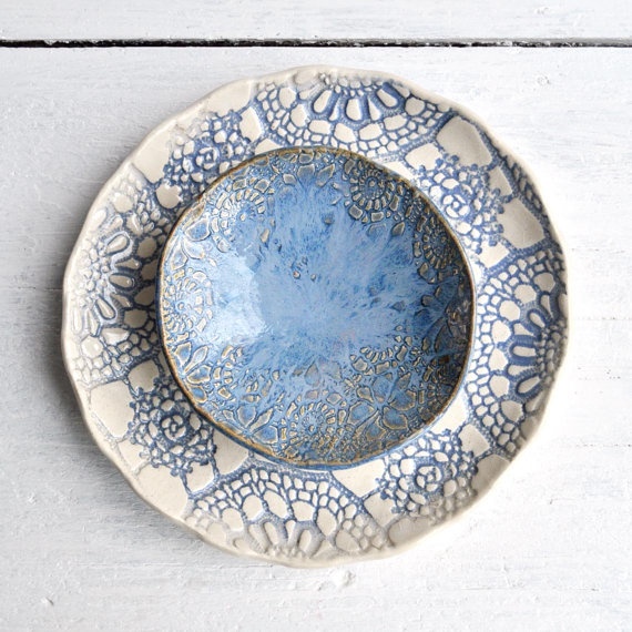 a blue and white plate sitting on top of a wooden table next to a wall