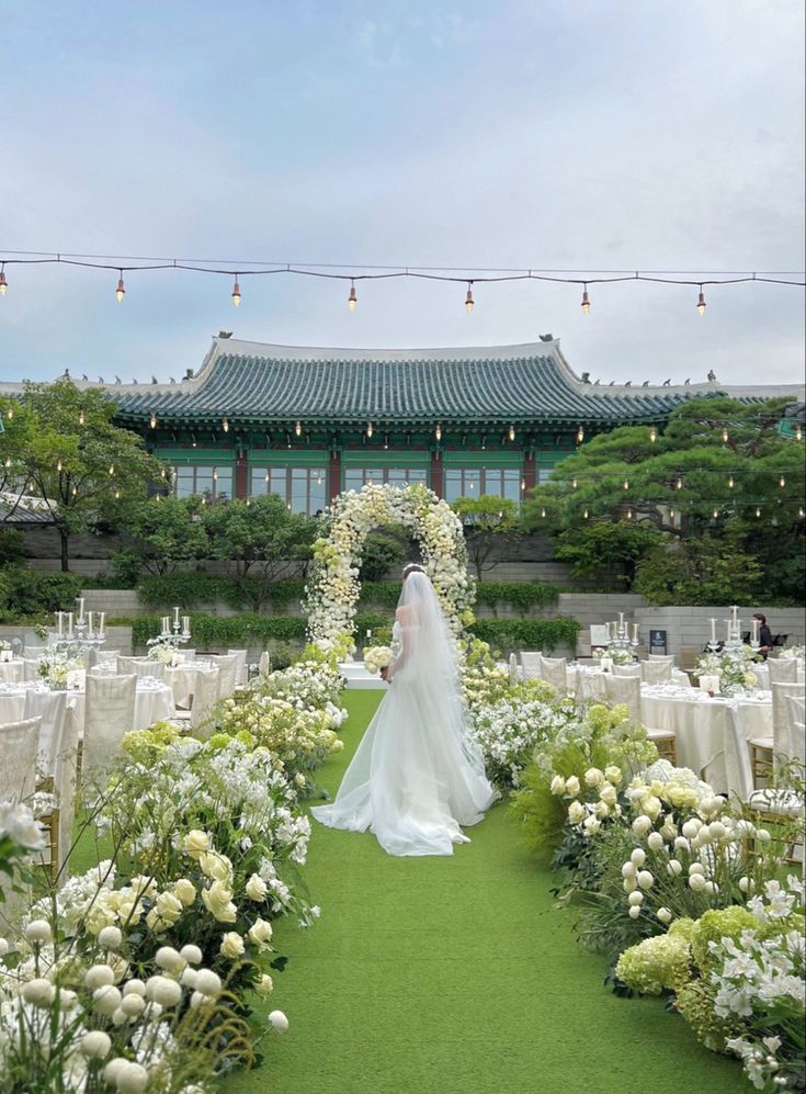 a bride and groom are standing in the middle of an outdoor garden with white flowers