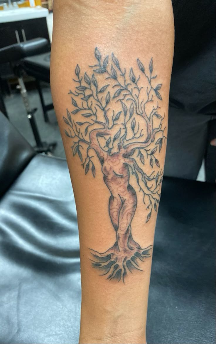 a tattoo on the leg of a person with an image of a tree in it